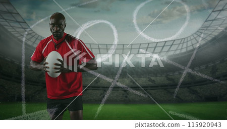 Image of an African American male rugby player standing, playing with a ball and looking to camera w Image of an African American male rugby player standing, playing with a ball and looking to camera w 115920943