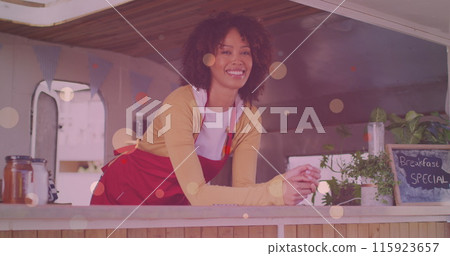 Image of yellow dots over happy biracial waitress looking at camera Image of yellow dots over happy biracial waitress looking at camera 115923657