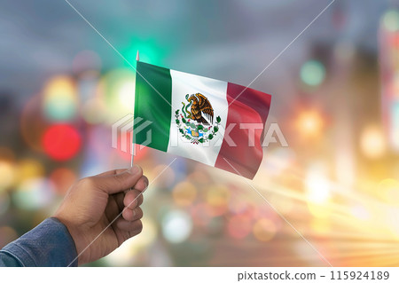 Generative AI Image of Hand Holding a Mexican Flag in Mexico Independence Day on Blur Background Generative AI Image of Hand Holding a Mexican Flag in Mexico Independence Day on Blur Background 115924189