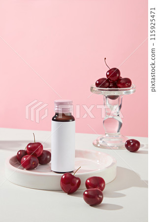 The photo with cherry theme for advertise beauty care products with fruit origin, an unlabeled bottle placed on white tray with some cherries decorated beside, over pastel pink background 115925471