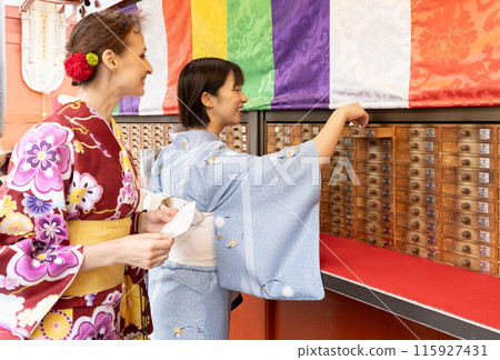 A foreign woman in a kimono drawing a fortune and a Japanese woman guiding her A foreign woman in a kimono drawing a fortune and a Japanese woman guiding her 115927431