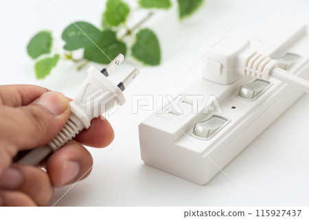 Hands of a man unplugging a power strip 115927437