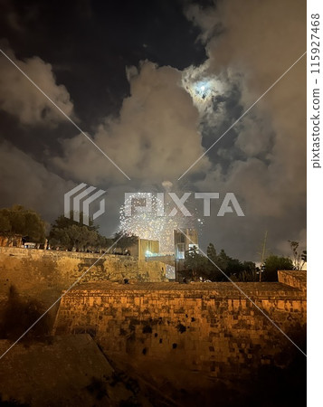 Fireworks over the walls of the old city of Valetta, Malta with panoramic view in a cloudy night 115927468