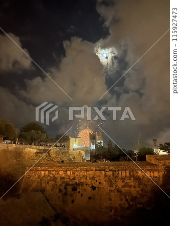 Fireworks over the walls of the old city of Valetta, Malta with panoramic view in a cloudy night 115927473