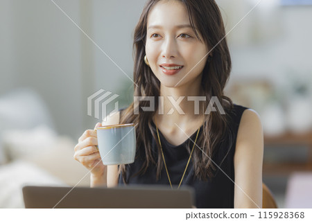 A young woman teleworking in the living room 115928368