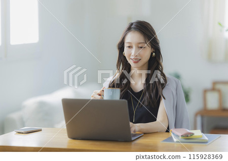 A young woman teleworking in the living room 115928369
