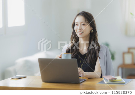 A young woman teleworking in the living room 115928370