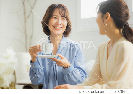 Two women having a conversation in a cafe 115928663