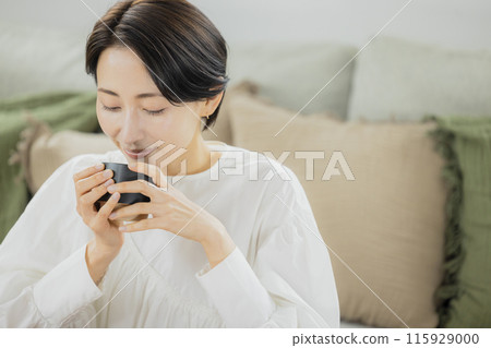 中年婦女在客廳喝咖啡 中年婦女在客廳喝咖啡 115929000