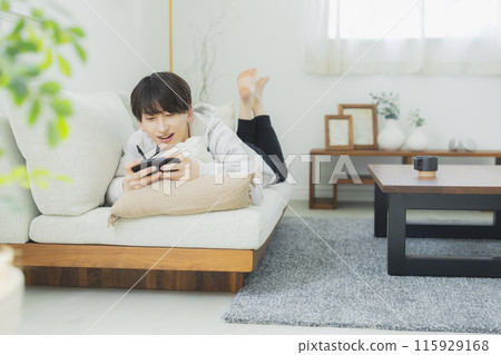 Young man relaxing in the living room 115929168