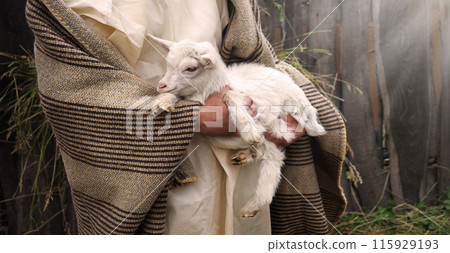 Shepherd with a sheep in his arms 115929193
