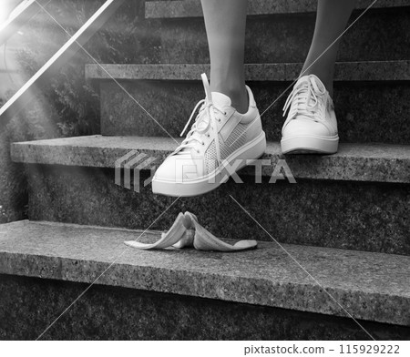 Foot stepping on a banana peel on steps Foot stepping on a banana peel on steps 115929222
