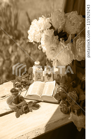 Book and coffee near a bouquet of flowers Book and coffee near a bouquet of flowers 115929243
