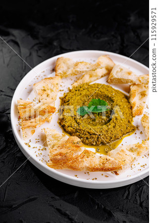 Fresh pesto dip with pita bread on elegant plate 115929571