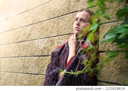 Sad girl near the wall 115929614