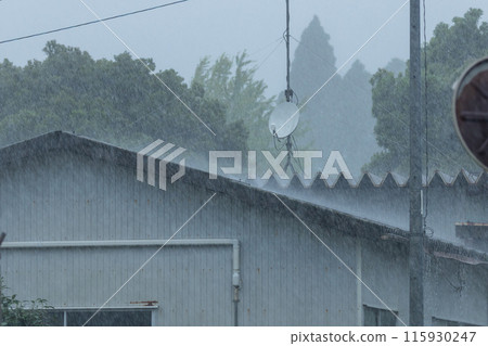 大雨正在襲擊安裝衛星天線的倉庫屋頂。 大雨正在襲擊安裝衛星天線的倉庫屋頂。 115930247