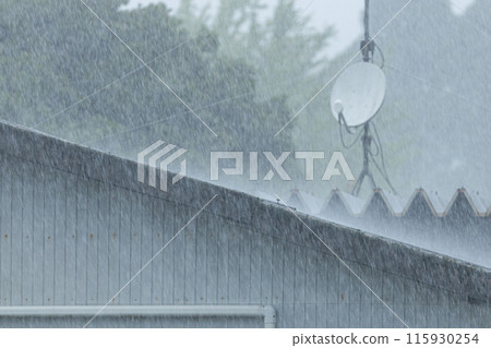 大雨正在襲擊安裝衛星天線的倉庫屋頂。 大雨正在襲擊安裝衛星天線的倉庫屋頂。 115930254