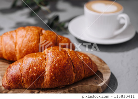 Fresh croissants and coffee on table 115930411
