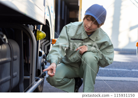 A young female truck driver inspecting the vehicle A young female truck driver inspecting the vehicle 115931150