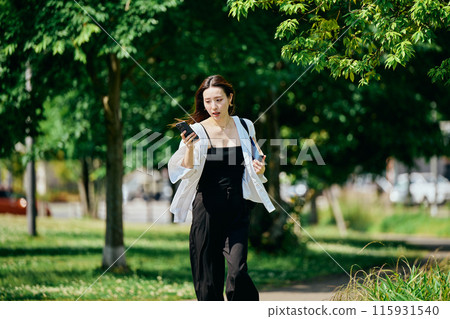 Young woman running in the city with a smartphone 115931540