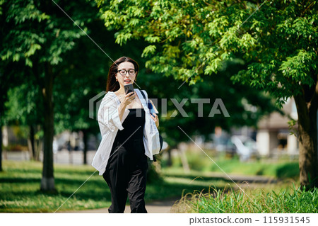 一位年輕女子帶著智慧型手機在城市中奔跑 115931545
