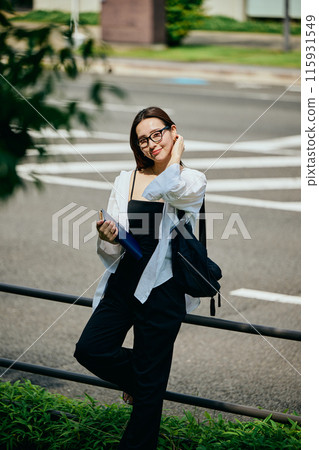 A young woman walking with a notebook 115931549