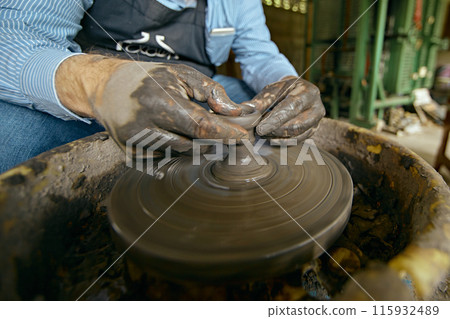 Hands of craftsman artist working on pottery wheel. Hands of craftsman artist working on pottery wheel. 115932489