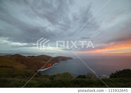 A beautiful sunset over the ocean with a cloudy sky A beautiful sunset over the ocean with a cloudy sky 115932645