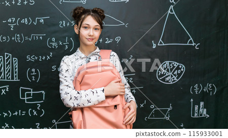 Portrait of a schoolgirl with a school bag on her shoulder, a student with a bag standing at the blackboard Portrait of a schoolgirl with a school bag on her shoulder, a student with a bag standing at the blackboard 115933001