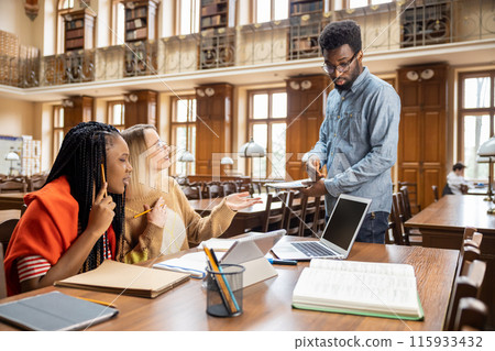 Group of young people discussing something in the library 115933432