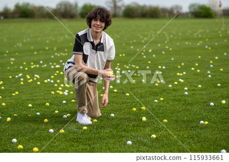 Dark-haired young guy training in a golf club 115933661