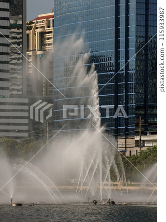 An Impressive Ornamental Pond water Fountain in front of Modern buildings. An Impressive Ornamental Pond water Fountain in front of Modern buildings. 115933987