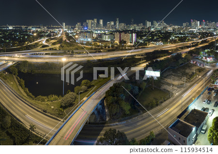 Above view of wide highway crossroads in Miami, Florida at night with fast driving cars. USA transportation infrastructure concept 115934514