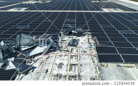Broken down photovoltaic solar panels destroyed by hurricane Ian winds mounted on industrial building roof for producing green ecological electricity. Consequences of natural disaster Broken down photovoltaic solar panels destroyed by hurricane Ian winds mounted on industrial building roof for producing green ecological electricity. Consequences of natural disaster 115934530