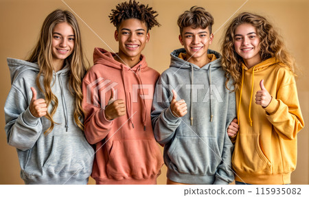 Four young people are standing together, all wearing hoodies 115935082