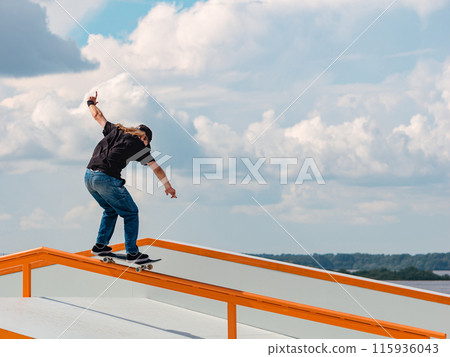 Young man doing jump trick on skateboard Young man doing jump trick on skateboard 115936043