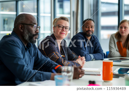Portrait of colleagues at a joint business meeting, selective focus on woman in the center of the frame, diverse group of professionals participating in a business meeting in a modern office 115936489