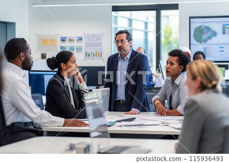 A group of employees working together in an office and having a panel discussion, they are focused on the discussion and carefully listening to the speech of a colleague A group of employees working together in an office and having a panel discussion, they are focused on the discussion and carefully listening to the speech of a colleague 115936493
