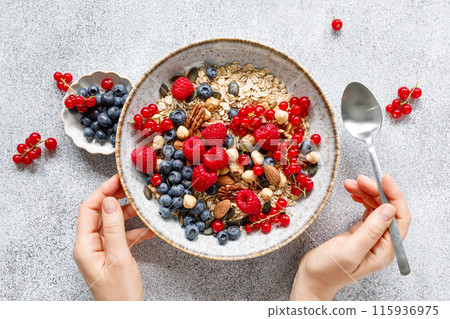 Muesli with organic berries and nuts. Oat muesli with raspberry, blueberry, red currant, almond, pecan, walnut, cashew, hazelnut and pumpkin seeds. Healthy food, top view 115936975