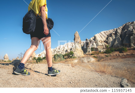 Tourist walking towards cave houses in Cappadocia mountain, Turkey 115937145