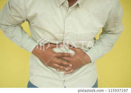 young man suffering stomach pain close up. young man suffering stomach pain close up. 115937197