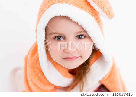 Little child wearing a bathrobe of peachy color, smiling shyly, hair under a hood Little child wearing a bathrobe of peachy color, smiling shyly, hair under a hood 115937416