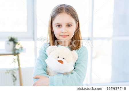 Cute little girl holding teddy bear in mask Cute little girl holding teddy bear in mask 115937746