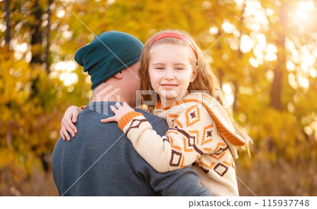 Father hugs with daughter on blurred autumn background Father hugs with daughter on blurred autumn background 115937748