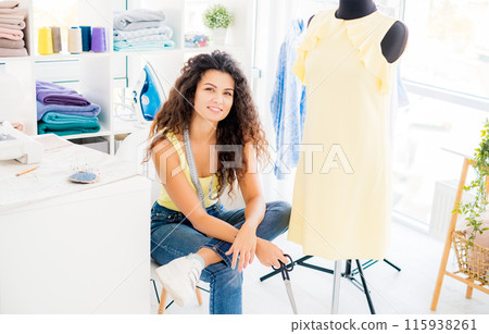 Satisfied creator near finished dress on mannequin in sewing studio Satisfied creator near finished dress on mannequin in sewing studio 115938261