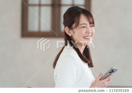 一個在辦公室使用智能手機的商人 一個在辦公室使用智能手機的商人 115939169
