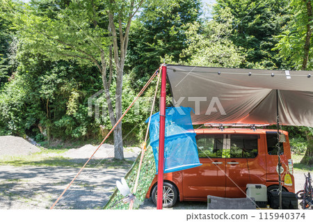 [Auto camping site: Tarp set up in the woods, hanging net] 115940374