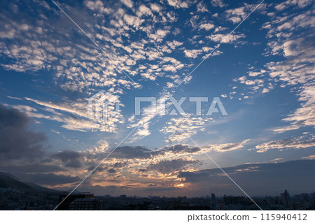 黎明在城市。東方的天空變亮了，雲升之前的太陽呈現出美麗的漸變。神戶市 115940412