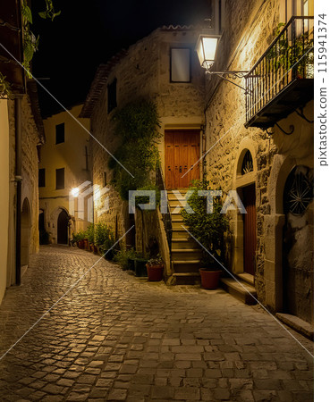 Cobblestone alley bathed in warm lights at dusk Cobblestone alley bathed in warm lights at dusk 115941374