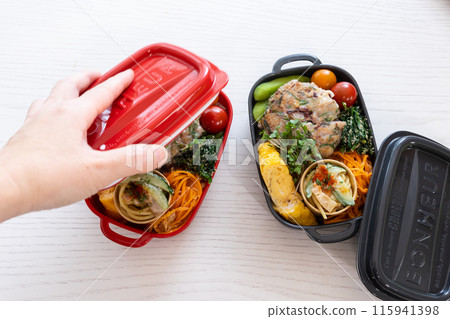 Woman's hand closing the lid of a lunch box 115941398